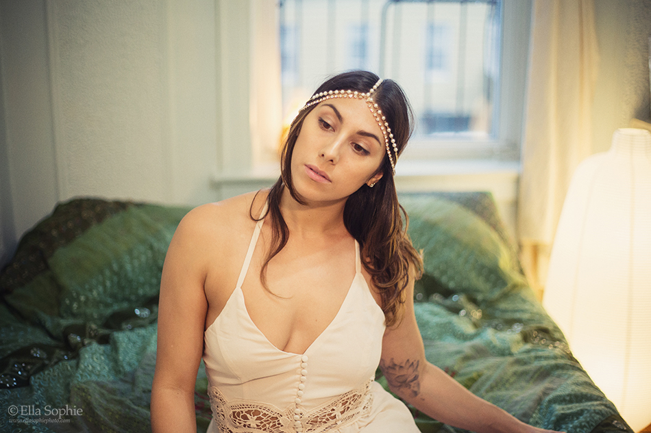 Subtle Oakland Boudoir woman sitting on bed wearing dress and jewelry