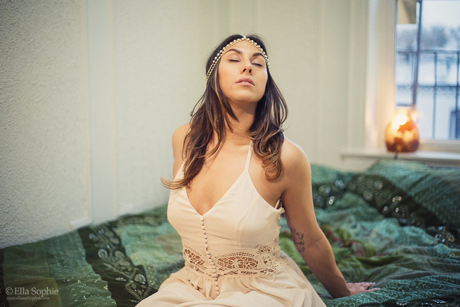 Dreamy oakland boudoir in bed, woman sitting wearing white dress, eyes closed