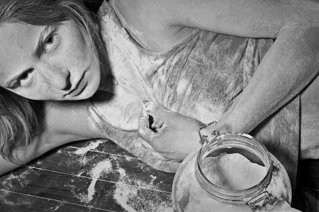 black and white portrait of woman covered in flour.