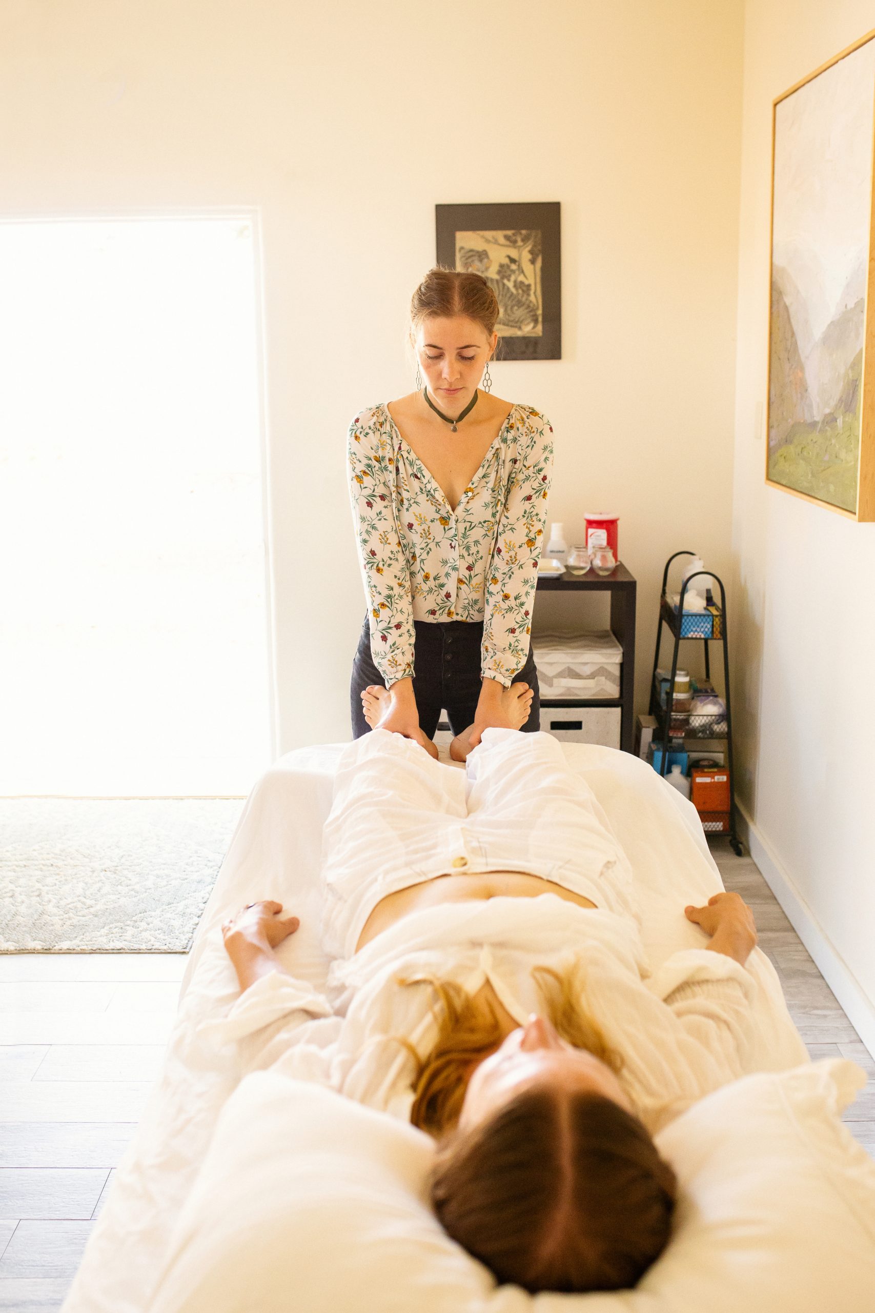 Branding images for Artemisia Clinic by Ella Sophie, Oakland professional photographer. Marketing photo shows doctor in health and wellness clinic providing foot massage to patient in warm, inviting lifestyle photo.