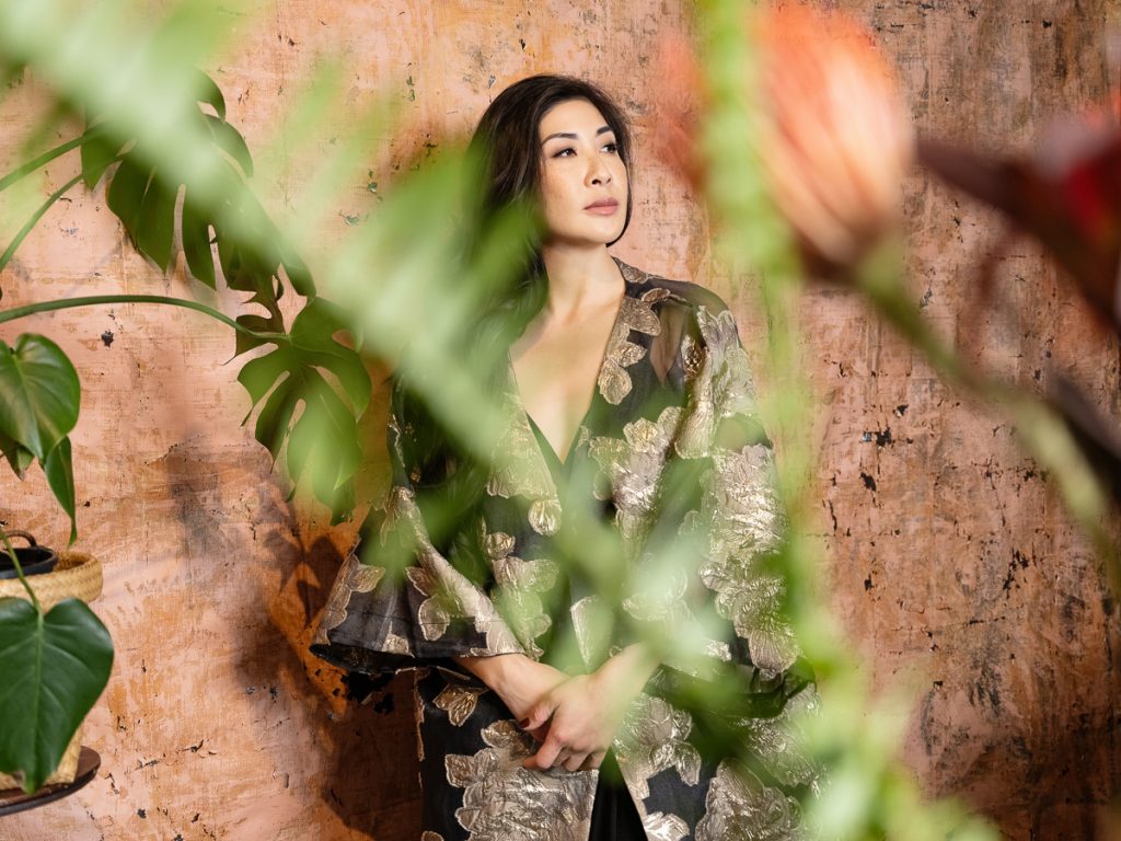 Creative, artistic portrait of woman wearing vintage kimono surrounded by plants