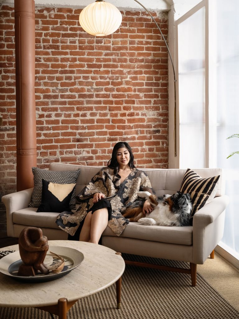 Personal Branding Portrait of woman wearing Kimono sitting on a couch with her dog. 